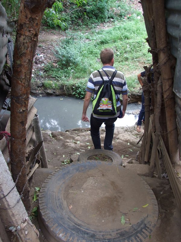 Nathan walking down their steps to leave - this is the “stream” of sewage the children jump every day to get to school and it’s low now