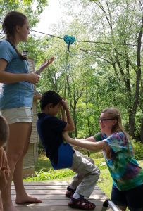 Sisters helping him on his first zip-line attempt.